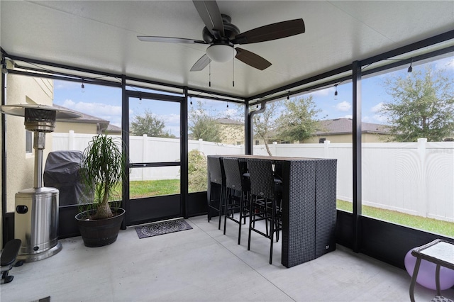 sunroom / solarium featuring ceiling fan