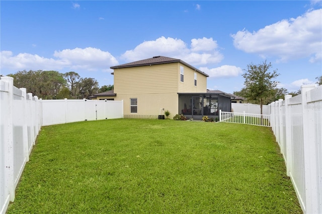 back of house featuring a lawn and a sunroom