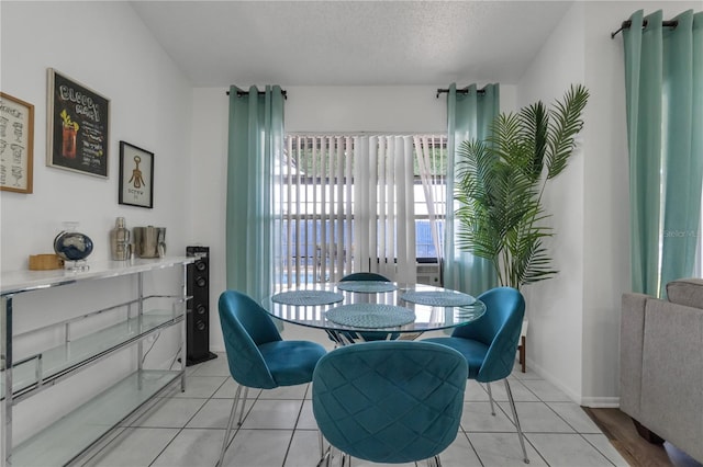 tiled dining space with a textured ceiling