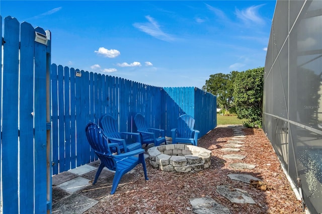 view of yard featuring an outdoor fire pit and a lanai