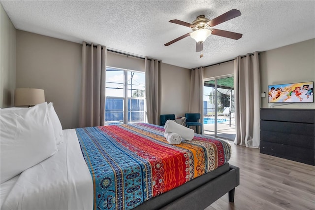 bedroom featuring ceiling fan, access to outside, a textured ceiling, and wood-type flooring