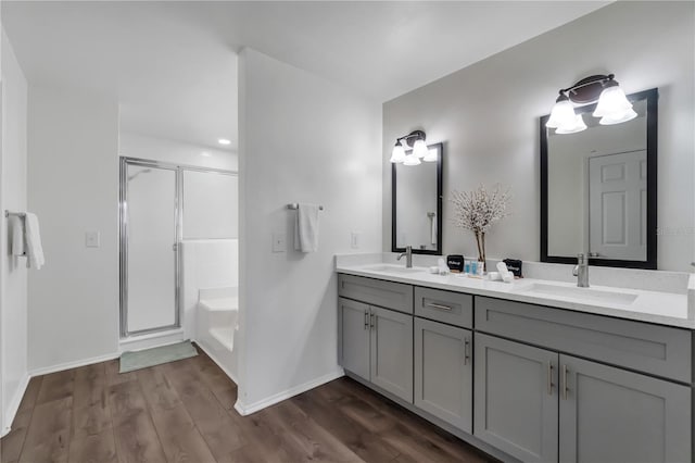 bathroom featuring hardwood / wood-style flooring, vanity, and shower with separate bathtub