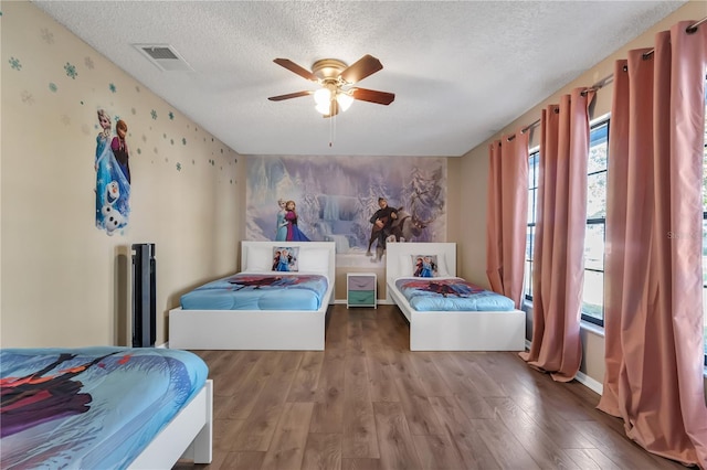 bedroom with hardwood / wood-style floors, a textured ceiling, and ceiling fan