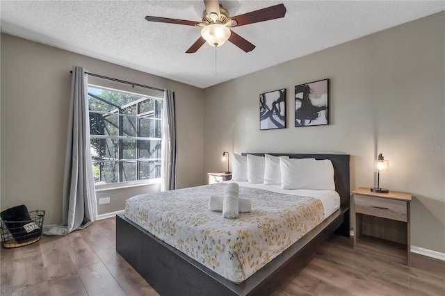 bedroom with ceiling fan, a textured ceiling, and hardwood / wood-style flooring