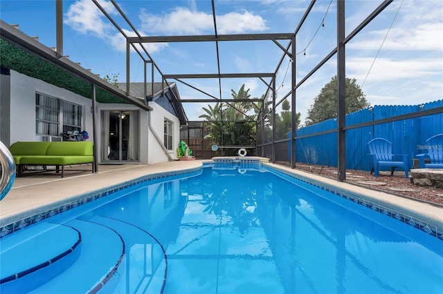 view of pool featuring glass enclosure and a patio area