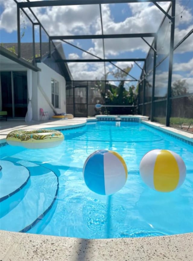 view of swimming pool featuring a lanai and a patio