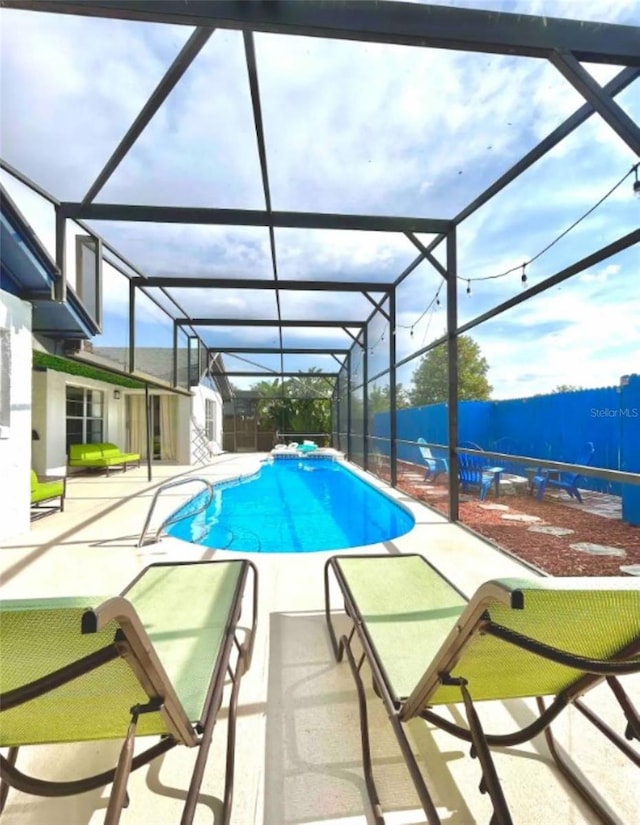 view of pool featuring glass enclosure and a patio area