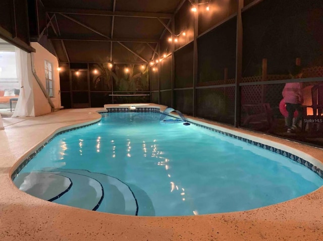 view of swimming pool with a patio area and a lanai