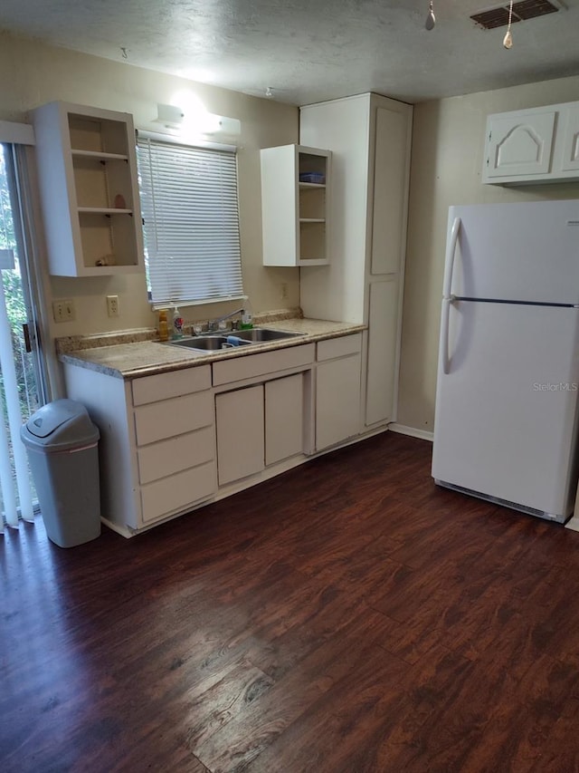 kitchen featuring white cabinets, dark hardwood / wood-style floors, sink, and white refrigerator