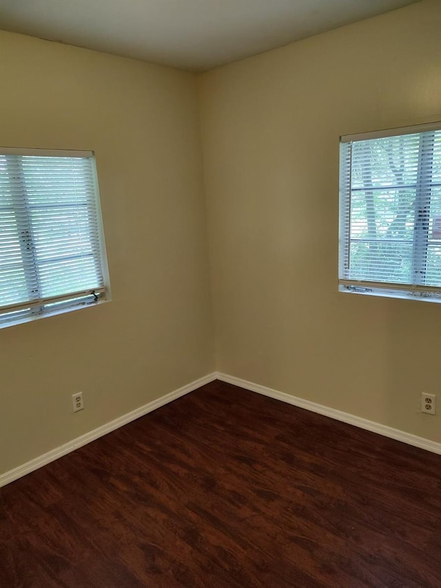 unfurnished room with dark wood-type flooring