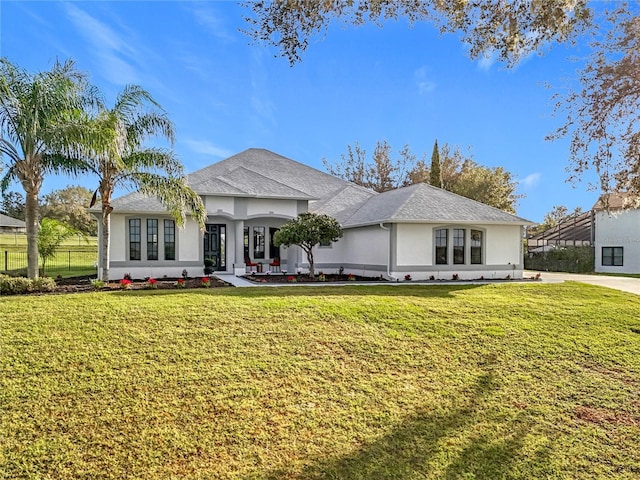 ranch-style home with a front lawn and french doors