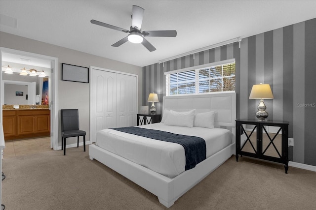 bedroom featuring light carpet, wallpapered walls, baseboards, and a closet