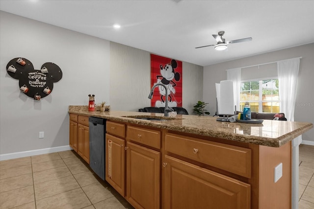 kitchen featuring brown cabinets, light tile patterned floors, stainless steel dishwasher, a sink, and a peninsula