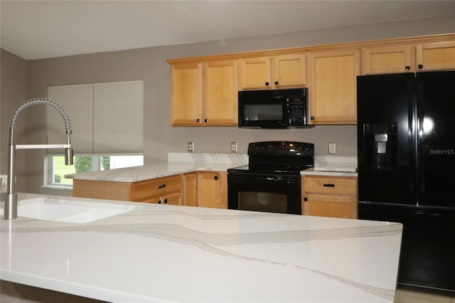 kitchen with light stone countertops, light brown cabinets, black appliances, and sink