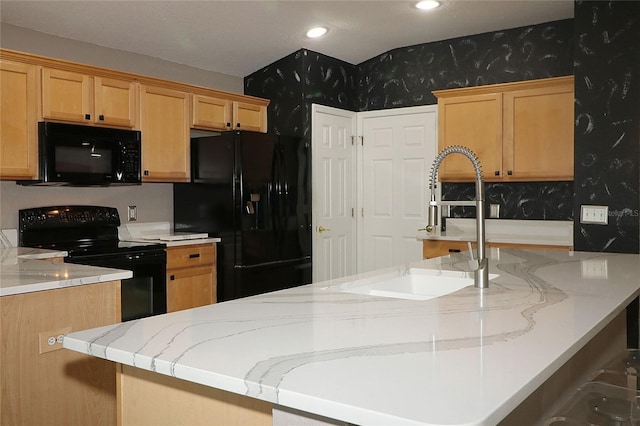 kitchen with a kitchen breakfast bar, light stone counters, sink, and black appliances