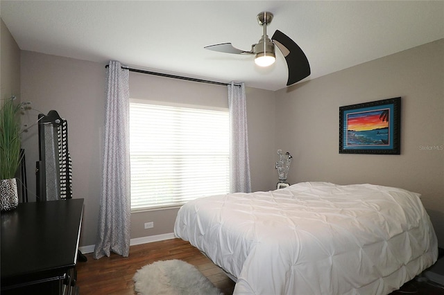 bedroom with dark hardwood / wood-style floors and ceiling fan