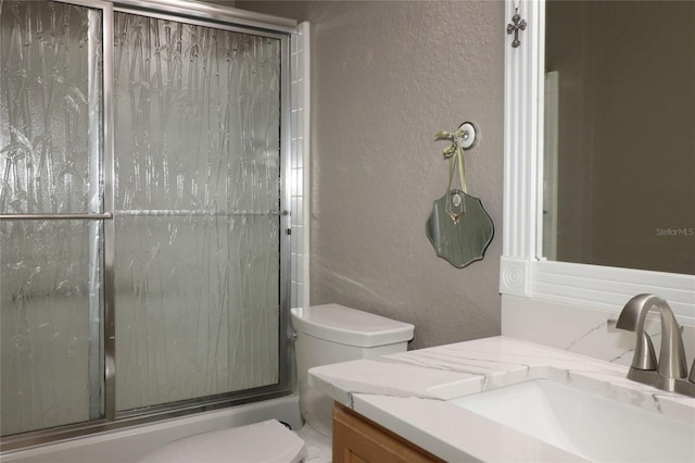 full bathroom featuring vanity, toilet, and bath / shower combo with glass door