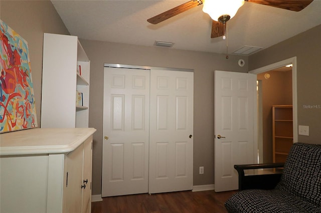 bedroom with a closet, dark hardwood / wood-style floors, and ceiling fan