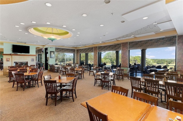 carpeted dining area with a raised ceiling and a textured ceiling