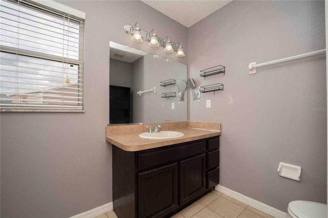 bathroom with tile patterned flooring, vanity, and toilet