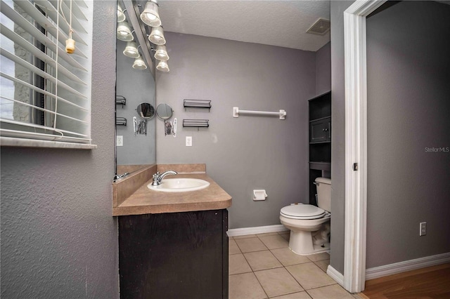 bathroom with vanity, tile patterned floors, toilet, and a textured ceiling