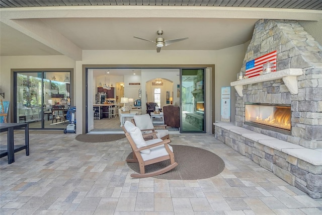 view of patio / terrace with ceiling fan and a stone fireplace