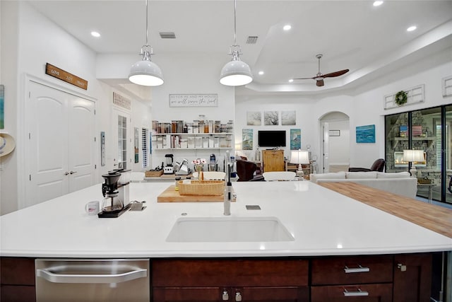 kitchen featuring pendant lighting, a kitchen island with sink, sink, ceiling fan, and dark brown cabinetry