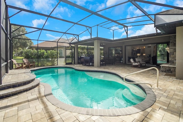 view of pool with a lanai, ceiling fan, and a patio area