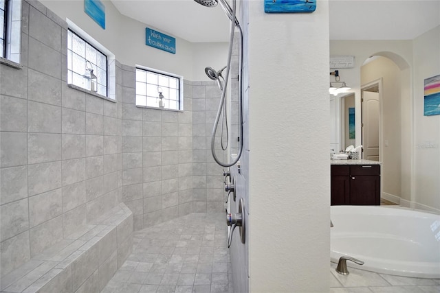 bathroom featuring a tile shower and vanity