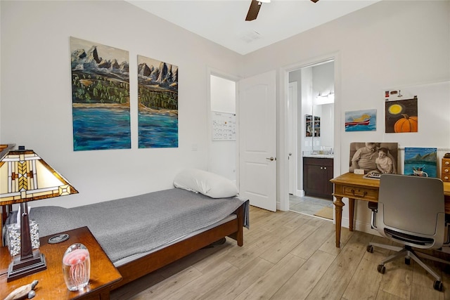 bedroom with light wood-type flooring, ensuite bath, and ceiling fan