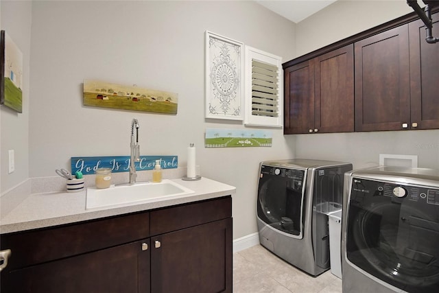 washroom featuring cabinets, light tile patterned flooring, washer and clothes dryer, and sink