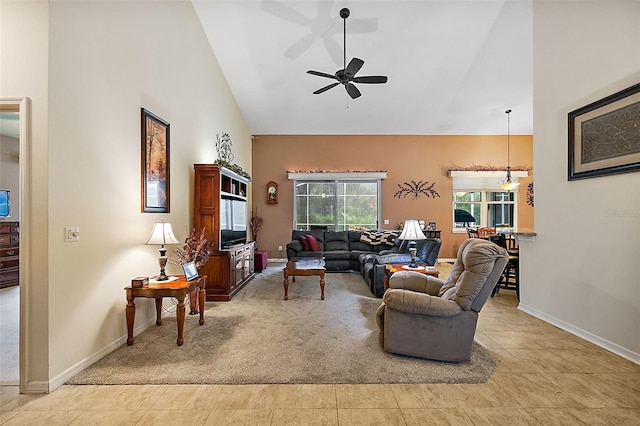 carpeted living room with ceiling fan and high vaulted ceiling