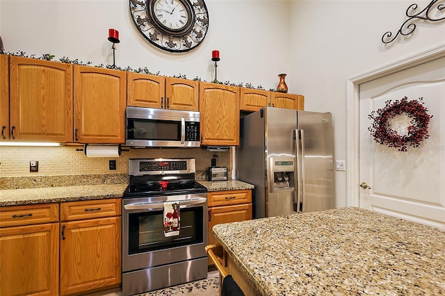 1720 Park Forest Blvd, Mount Dora, FL 32757 - kitchen featuring stainless steel appliances, backsplash, light stone countertops, and brown cabinets