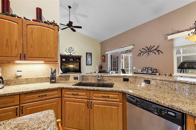 kitchen featuring sink, light stone counters, ceiling fan, stainless steel dishwasher, and lofted ceiling