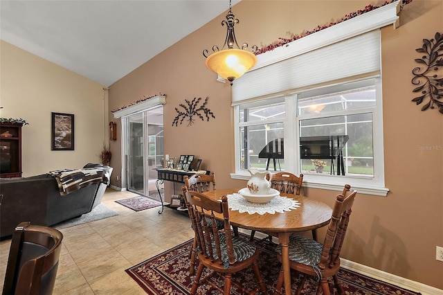 tiled dining area featuring vaulted ceiling