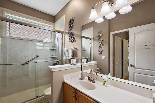 bathroom featuring vanity, toilet, and a shower with shower door