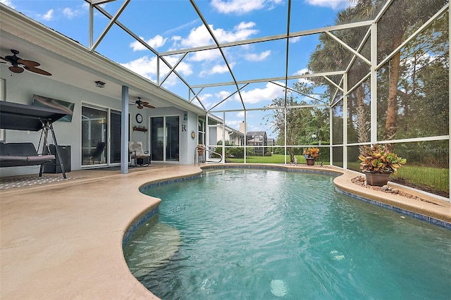 view of pool featuring glass enclosure, a patio area, and ceiling fan