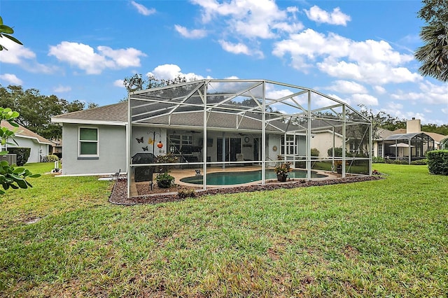 back of property featuring glass enclosure, a lawn, and a patio