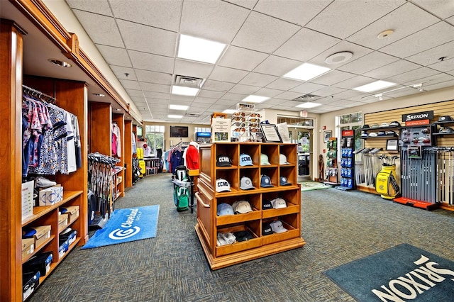 miscellaneous room featuring a paneled ceiling and dark carpet