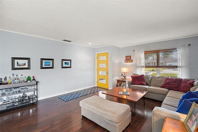 living room with dark wood-type flooring, a textured ceiling, and crown molding