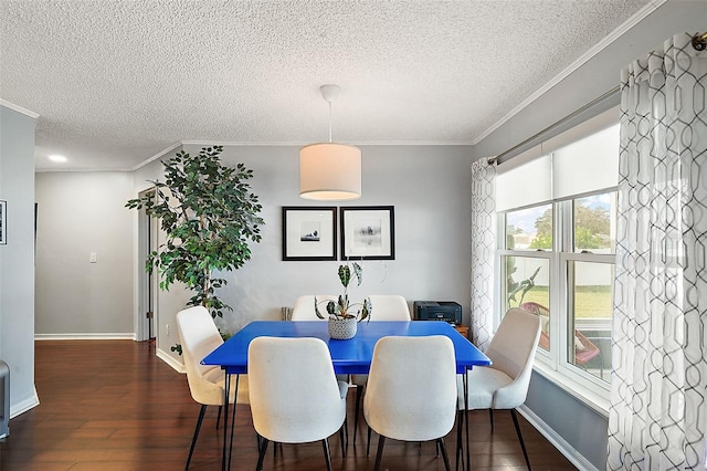 dining area with ornamental molding, dark wood-type flooring, and a textured ceiling