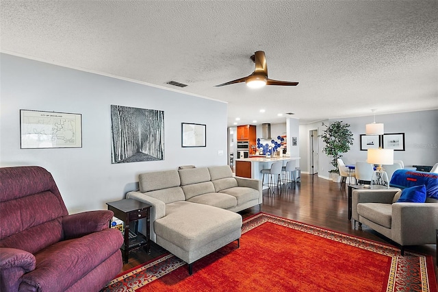 living room featuring a textured ceiling, wood-type flooring, and ceiling fan