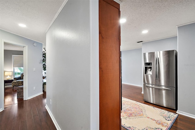 corridor featuring dark hardwood / wood-style floors, a textured ceiling, and ornamental molding