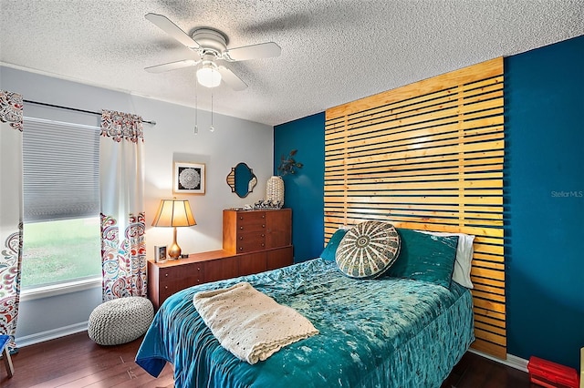 bedroom featuring ceiling fan, a textured ceiling, and dark hardwood / wood-style flooring