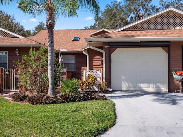 ranch-style house with a garage and a front lawn