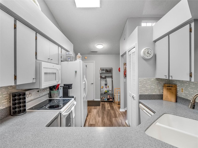 kitchen with dark wood-type flooring, white cabinets, sink, backsplash, and white appliances