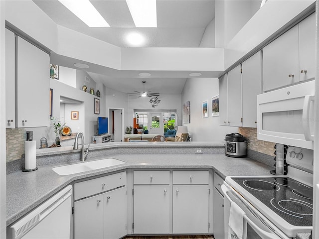 kitchen featuring white cabinets, lofted ceiling, sink, and white appliances