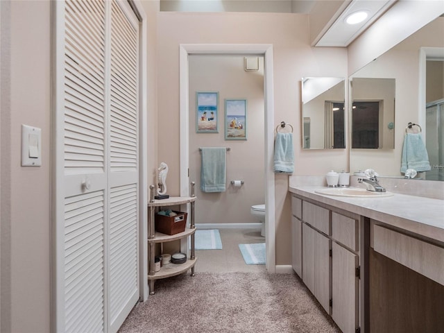 bathroom with tile patterned flooring, vanity, and toilet