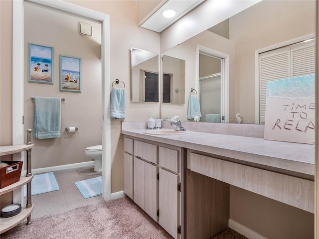 bathroom featuring toilet, vanity, tile patterned flooring, and walk in shower