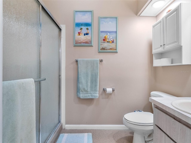 bathroom with toilet, vanity, and an enclosed shower